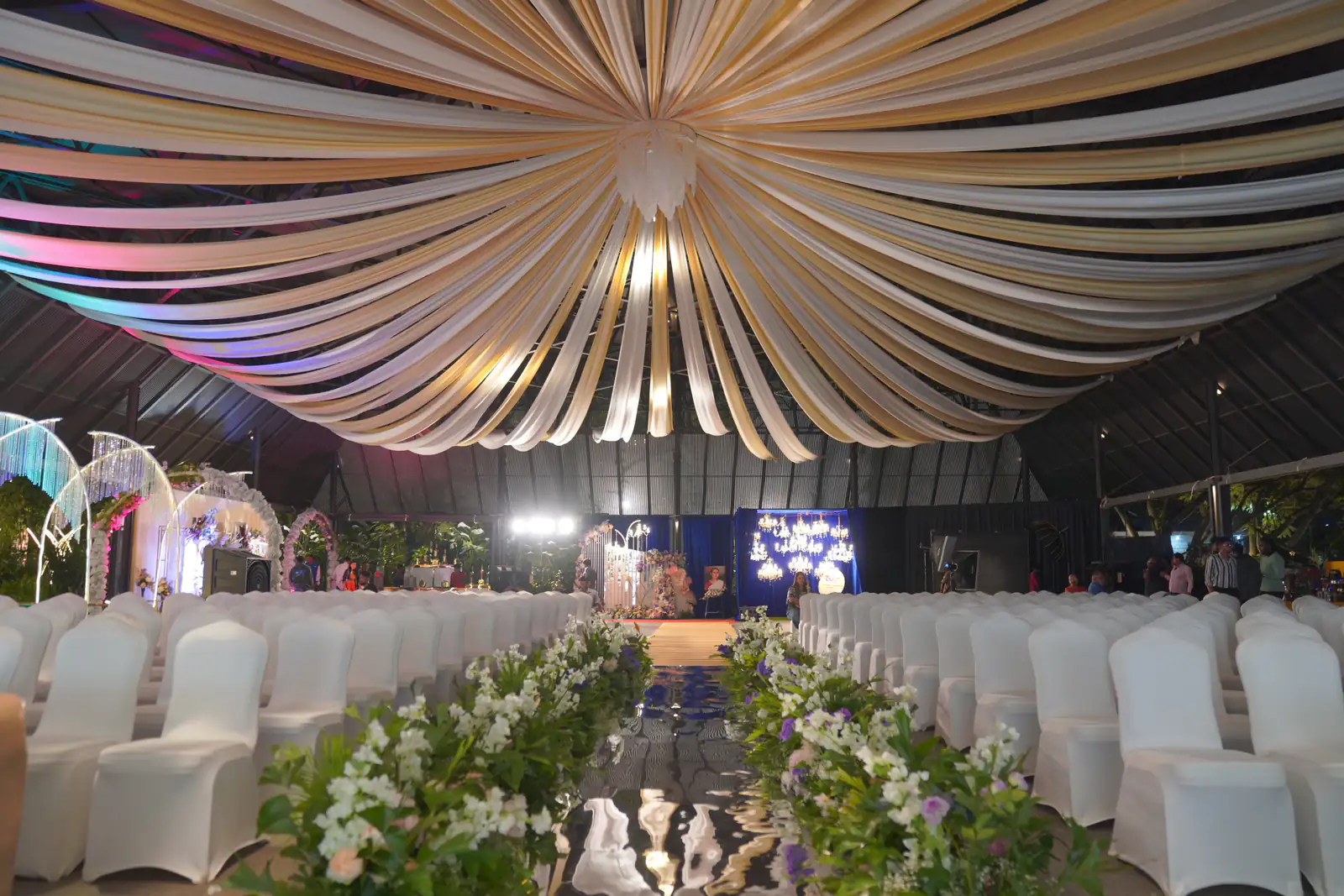 Reception under draped ceiling and floral aisle